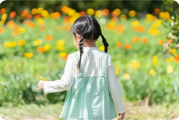 花畑を前に立つ後ろ姿の女の子