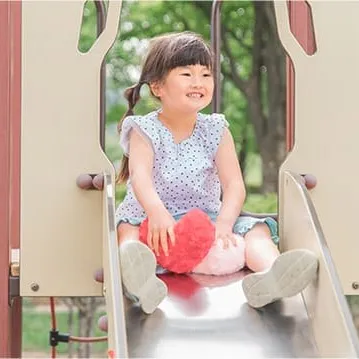 滑り台の上で笑う女の子