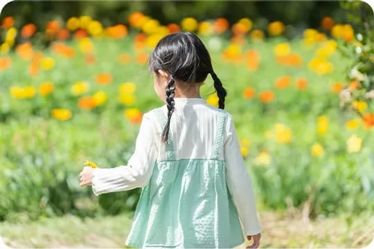 花畑を前に立つ後ろ姿の女の子