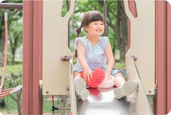 滑り台の上で笑う女の子