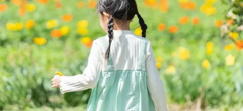 花畑を前に立つ後ろ姿の女の子